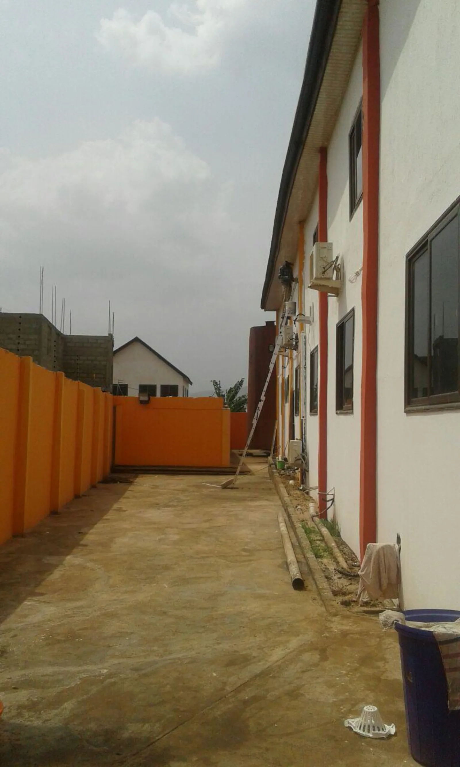 Side yard of the Oyarifa plant with a storage tank alongside the building